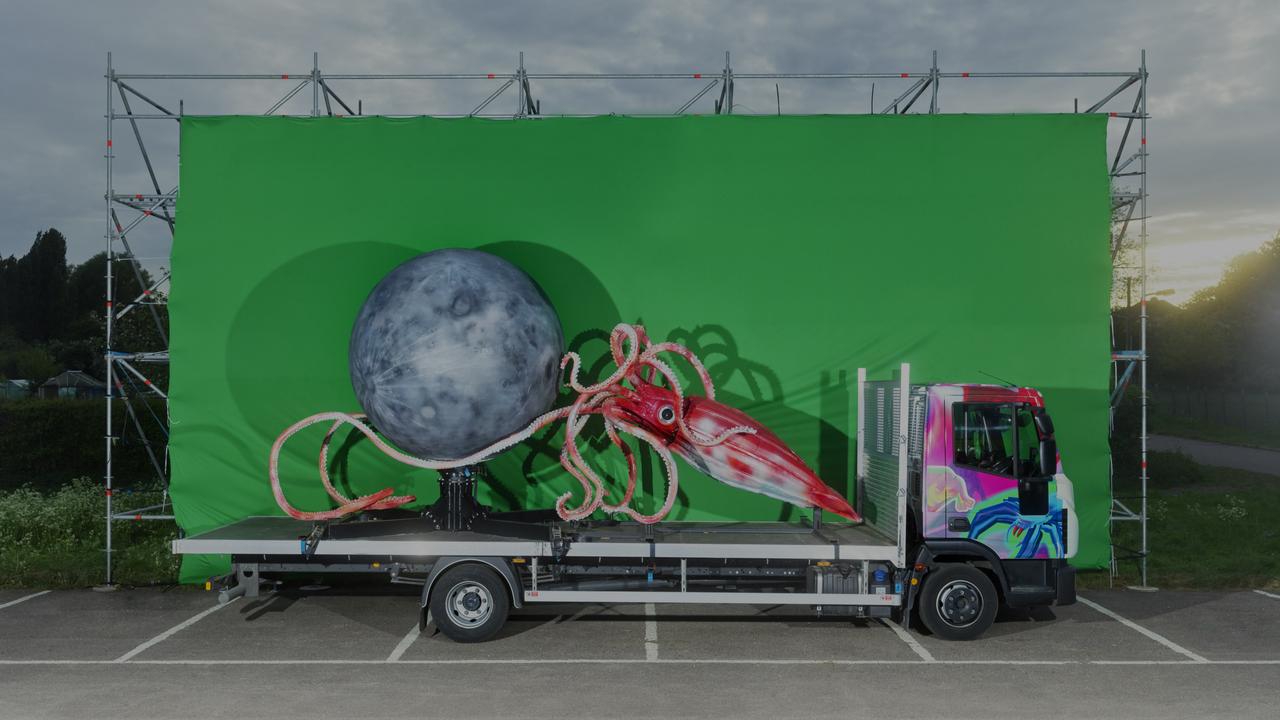 a giant squid and moon on the back of a truck in front of a green screen