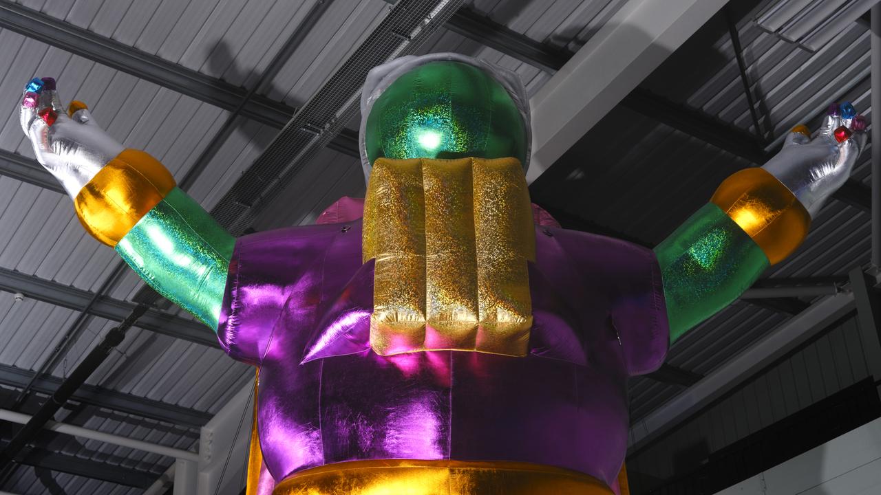 large inflatable green and purple astronaut inside large hall